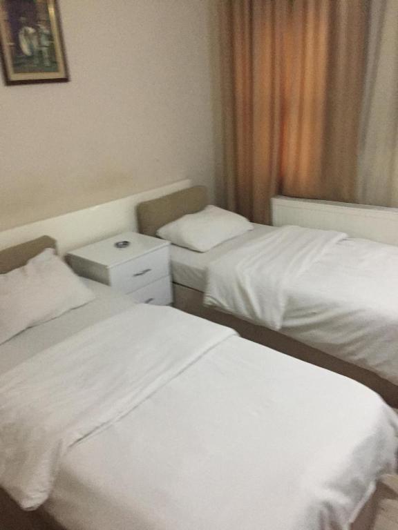 two beds in a hotel room with white sheets at Paxx Istanbul Hotel&Hostel in Istanbul