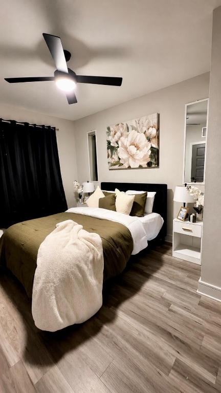 a bedroom with a large bed with a ceiling fan at Excel Grand Stays in Frisco