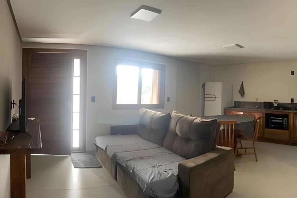 a living room with a couch and a kitchen at Casa das Bananeiras - 1 Quarto * Rota do Vinho in Bento Gonçalves