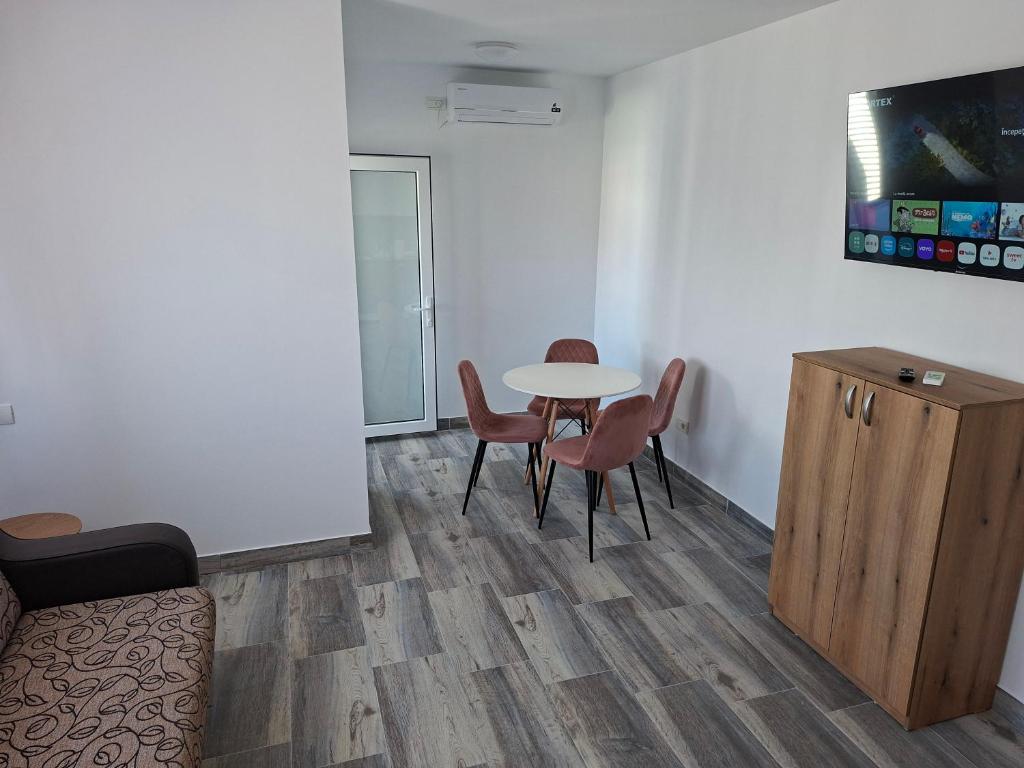 a room with a table and two chairs and a cabinet at Apartamente VILLA 7 On The Beach in Eforie Nord