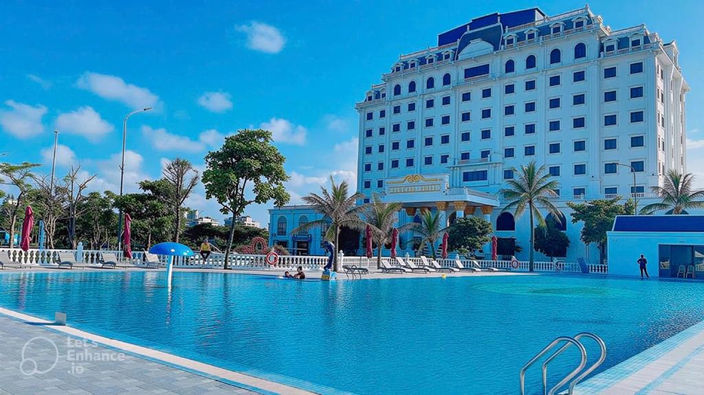 a hotel with a swimming pool in front of a building at Lan Chau Luxury Hotel in Cửa Lô