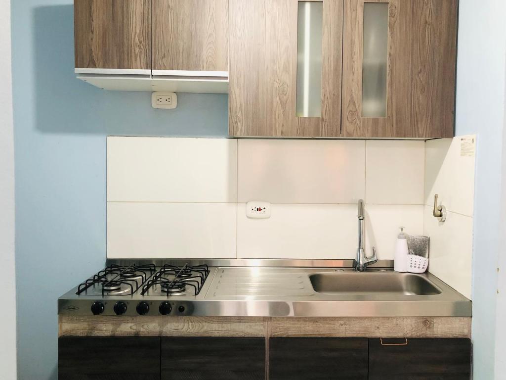 a kitchen with a sink and a stove at GV Aparta Suites Apto Familiar Amplio y Luminoso in Chía
