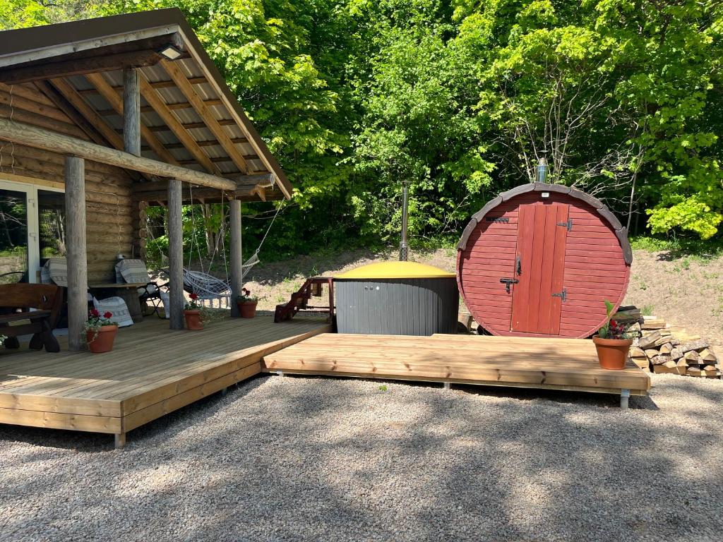 a wooden deck with a wooden door on a cabin at Miško sodyba in Gedvainiai