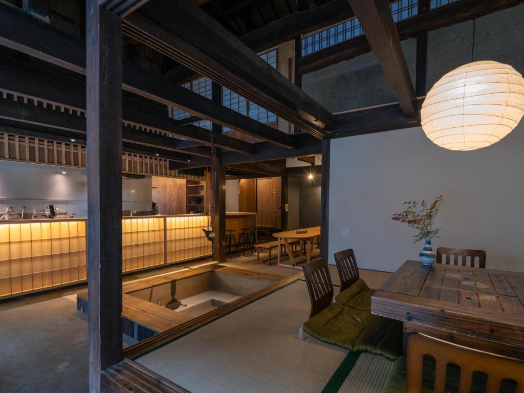 a dining room with a table and a kitchen at 汐見屋 in Tanabe