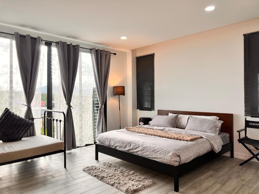 a bedroom with a bed and a large window at LECAR Home Shelby in Ban Nong Khang