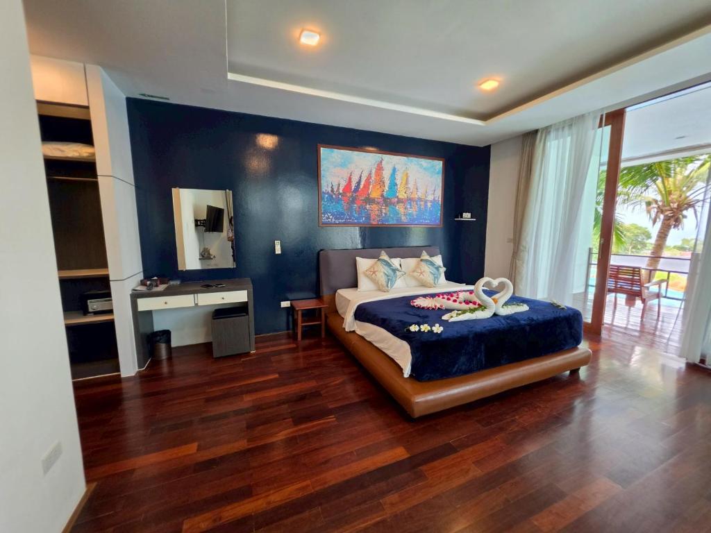 a bedroom with a bed with a blue wall at PP Mountain Beach Resort in Phi Phi Islands