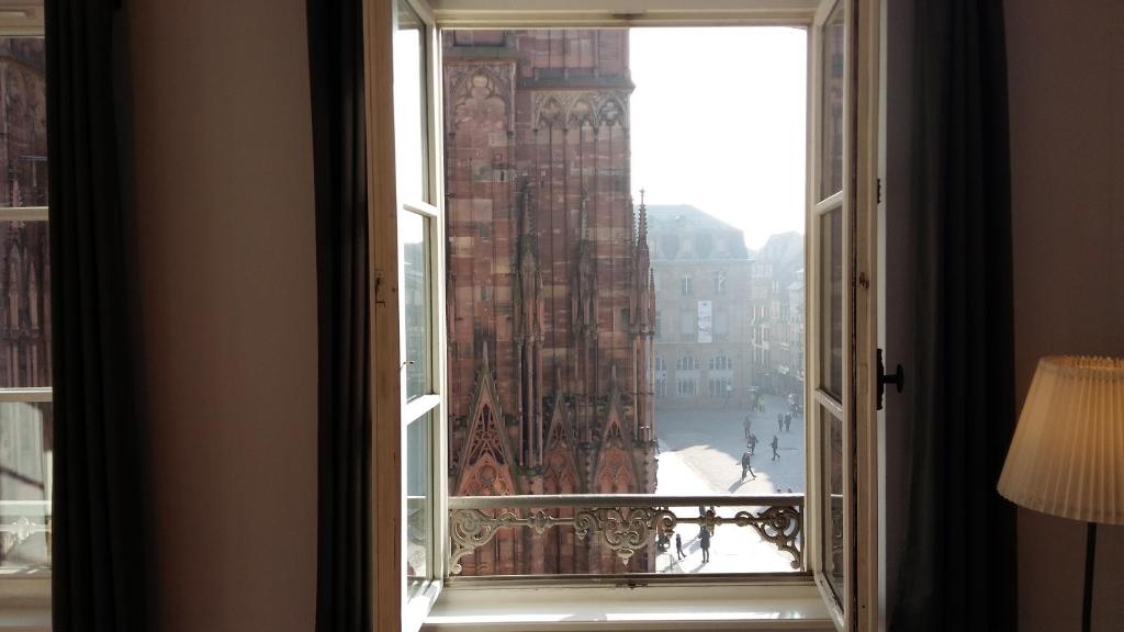 uma janela aberta com vista para uma cidade em Les appartements Place de la Cathédrale em Estrasburgo