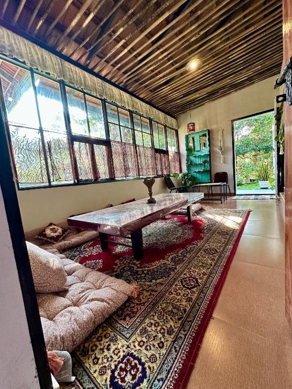 a living room with a table and a couch at Mass Bungalow in Tindummal