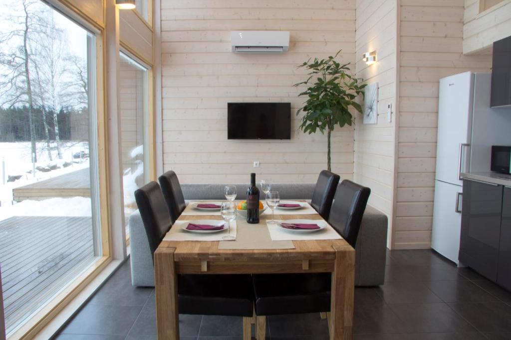 Ammatour Villas في Uro: غرفة طعام مع طاولة وكراسي خشبية
