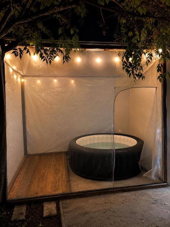 a large black tub in a tent with lights at Refugio del bosque - Casa con jacuzzi descanso en Piriapolis in Piriápolis