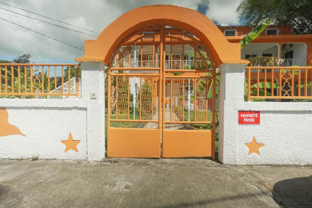 an orange door on a white building with stars on it at Sucriers in Garnier