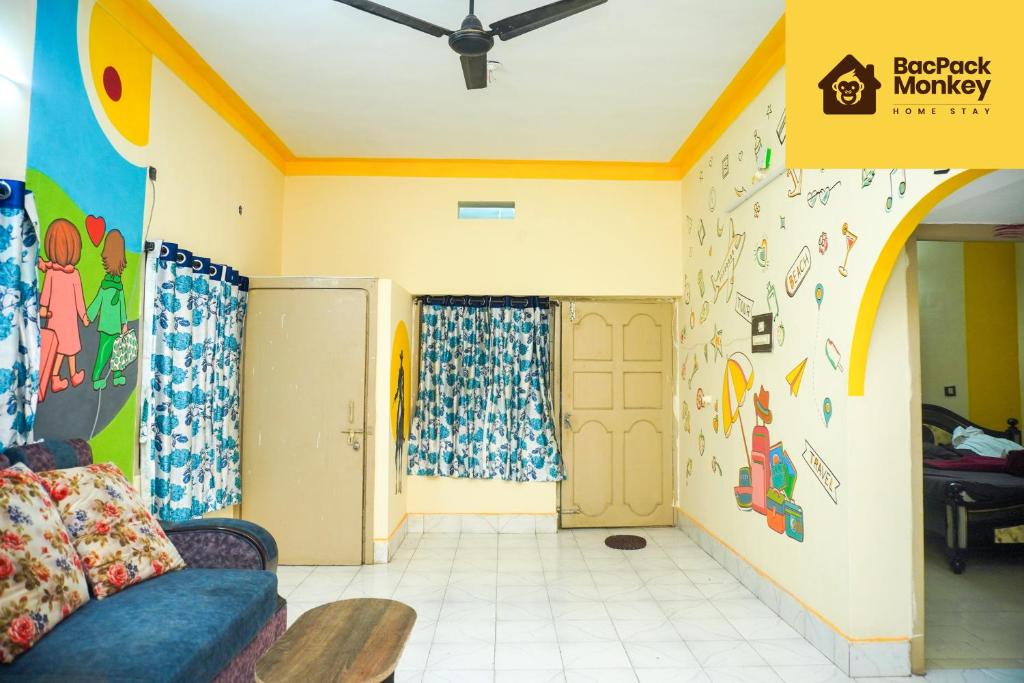 a living room with a couch and a wall with stickers at Zapstays-Homestays in Visakhapatnam