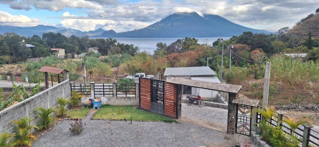a house with a gate and a view of a mountain at HOTEL D&S Ch'umil in Tzununá