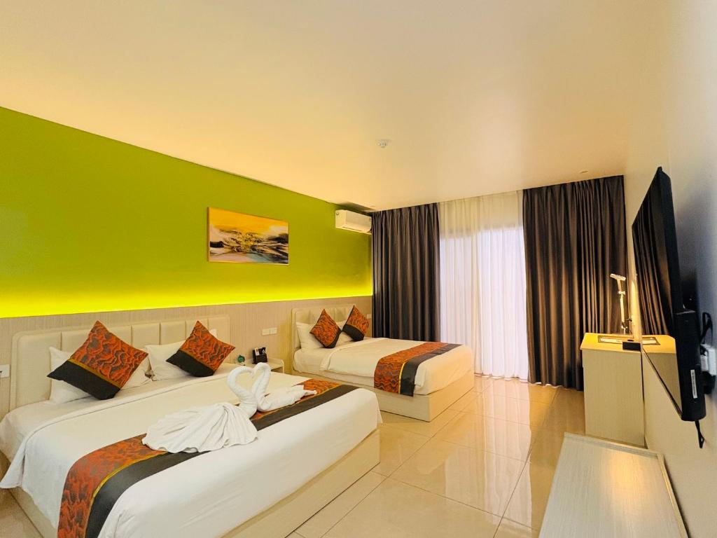 a hotel room with two beds and a green wall at Nausori Plaza Hotel in Vunimono