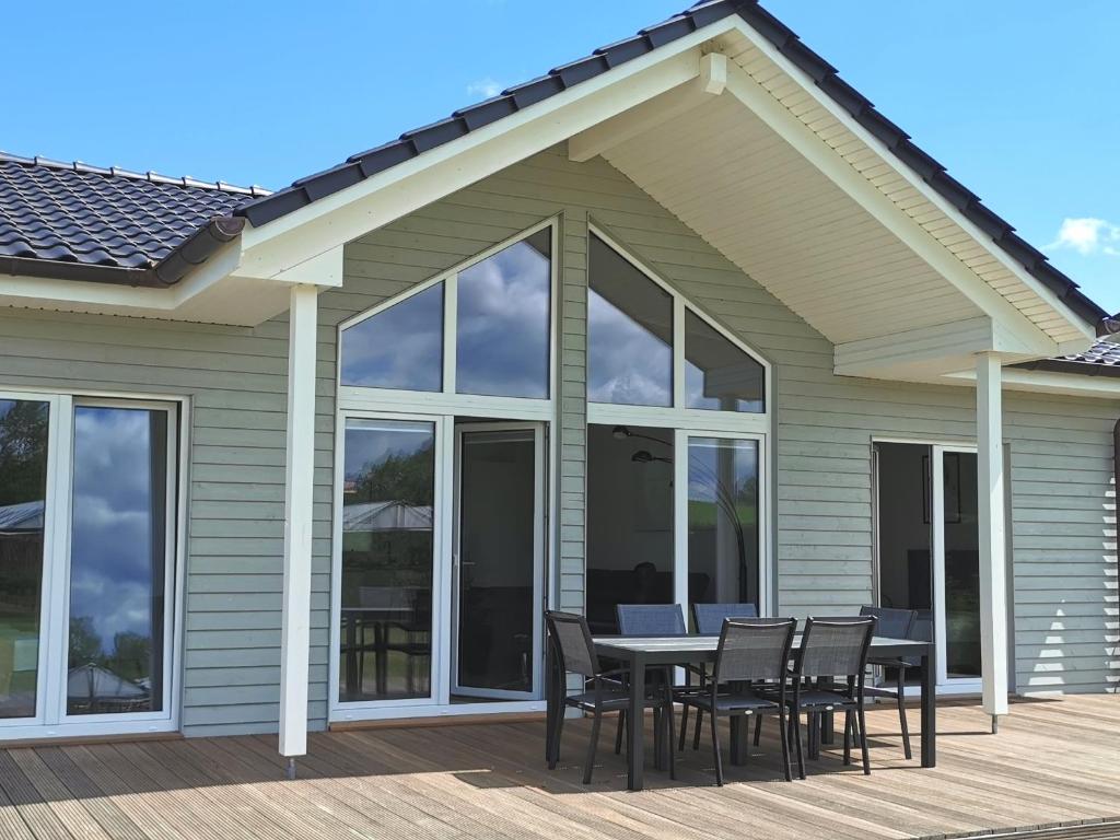 a patio with a table and chairs on a deck at Ferienhaus Elbdeichblick 2 in Haselau