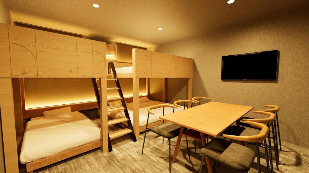 a room with a bunk bed and a table and a desk at The Base Sapporo Susukino in Sapporo