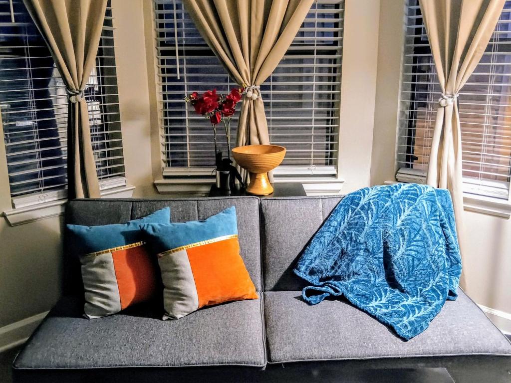 a couch with pillows and a blanket on it at The Serene Uptown Flat in Charlotte