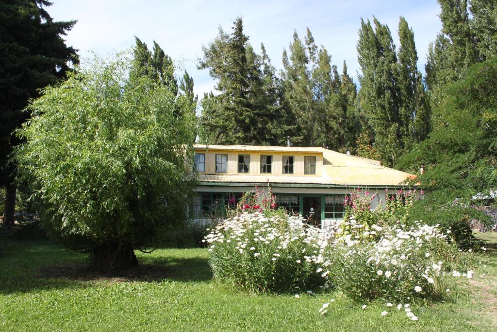 a house in the middle of a yard with flowers at Hostería de la Patagonia in Chile Chico