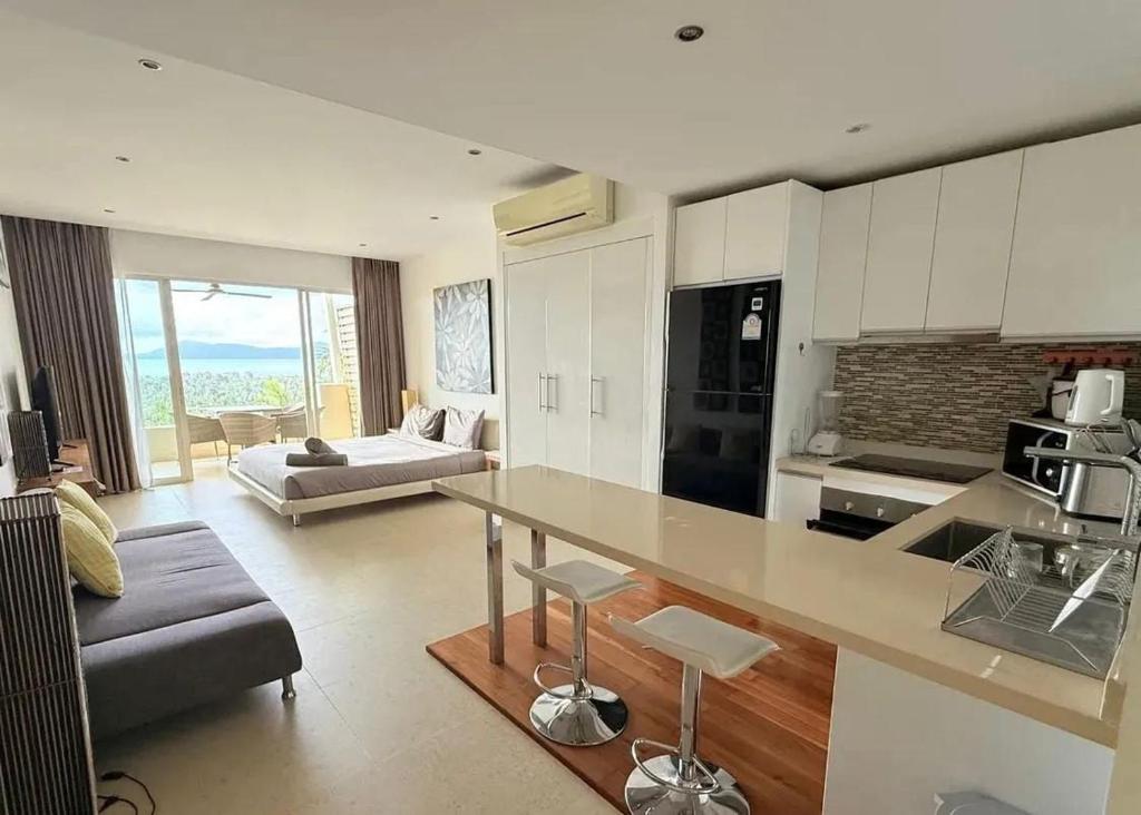a kitchen and living room with a table and a couch at Sea-view apartment in Azur in Ban Tai