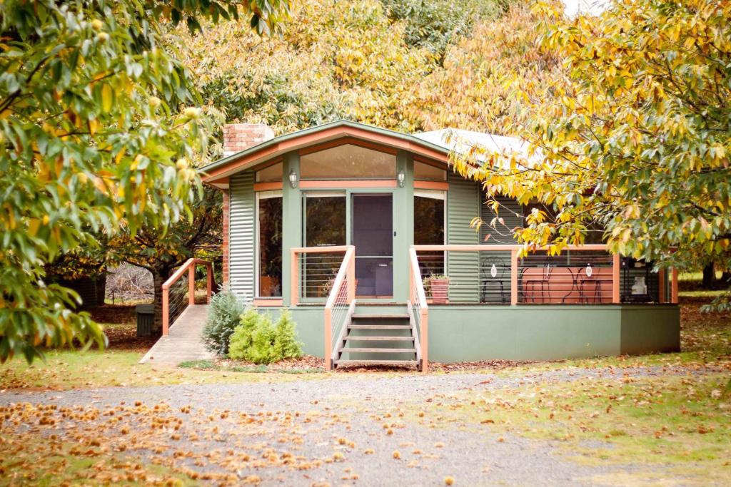 a small house with a porch and a deck at Chestnut Glade in Narbethong