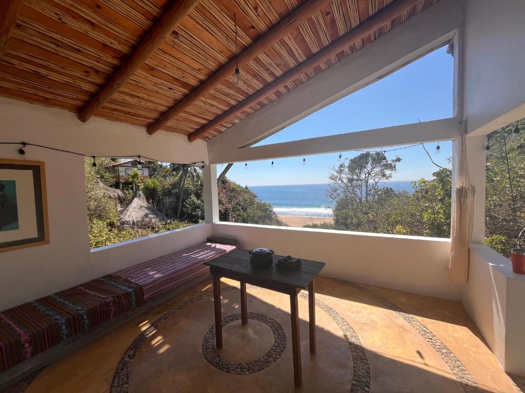 a room with a table and a view of the ocean at Casa Nisadó in San Agustinillo