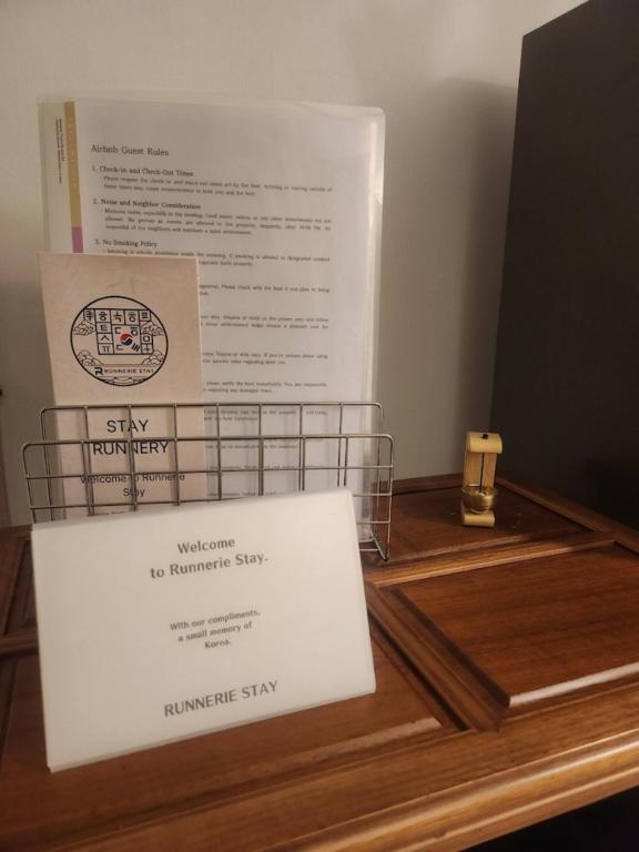 a sign on top of a wooden table with a box at 러너리 스테이 in Seoul