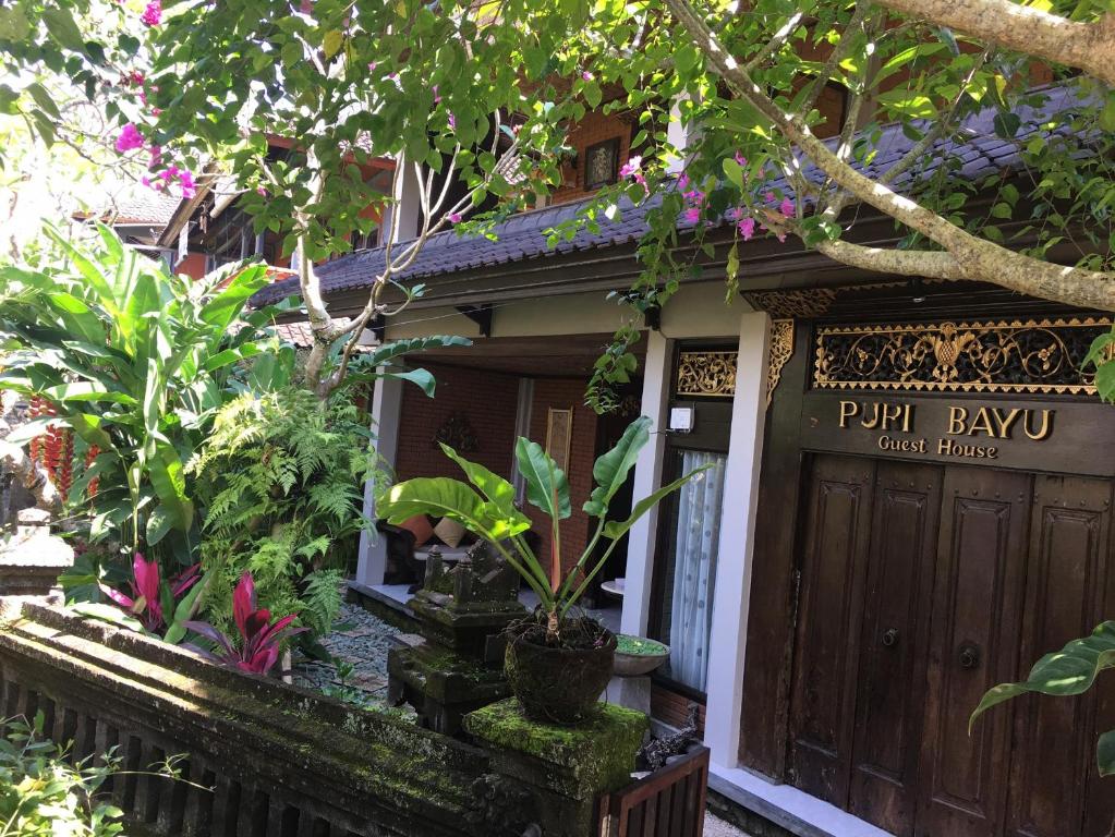 eine Haustür eines Hauses mit Pflanzen und Blumen in der Unterkunft Puri Bayu in Ubud