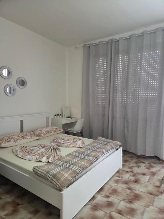 a white bedroom with a bed and a desk at Cosy Corner in Tollo