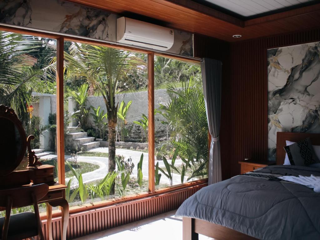 a bedroom with a large window looking out at a garden at The Garden Sanctuary Homestay in Sidemen