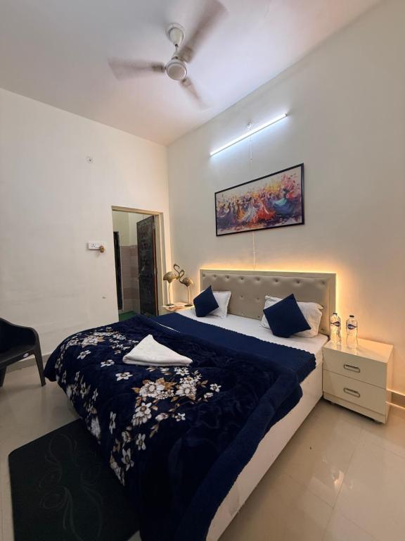 a bedroom with a large bed with a blue comforter at Devansh Palace Near Ram Mandir in Ayodhya