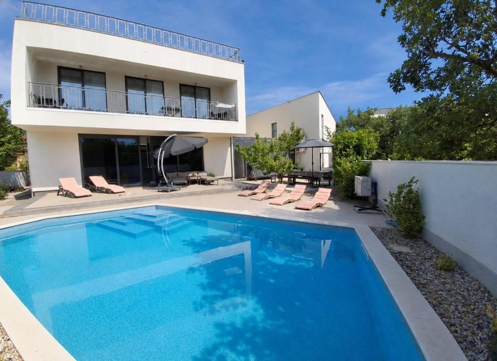 a swimming pool in front of a house at Villa Martina Bellevue in Šmrika