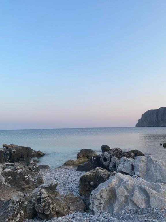 a beach with rocks and the ocean in the background at Mani Spot by the Sea in Gerolimenas