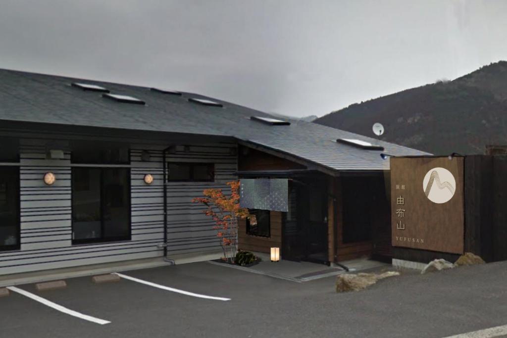 a building with a parking lot in front of it at Ryokan Yufusan in Yufu