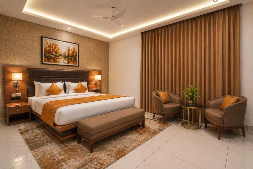 a hotel room with a bed and two chairs at Hotel Grand Regency by JMD Group Near Delhi IGI Airport in New Delhi