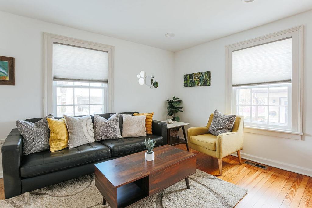 a living room with a black leather couch and a table at Green on New in Staunton