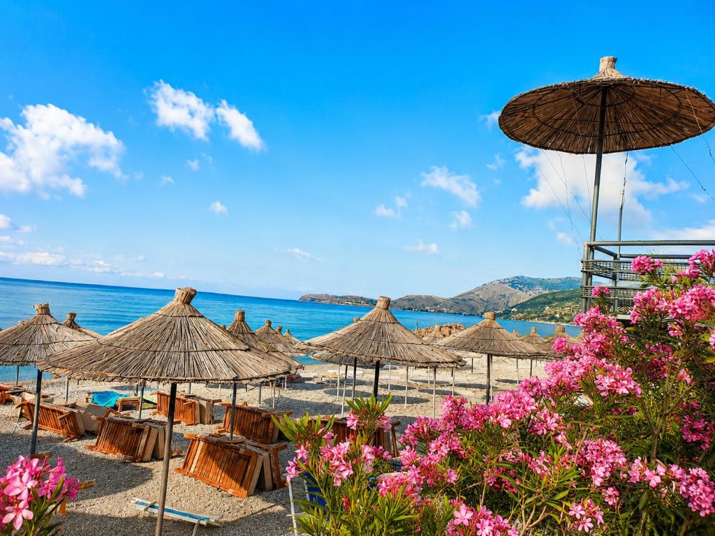 a group of umbrellas and chairs on a beach at Beautiful Sea View Borsh in Borsh
