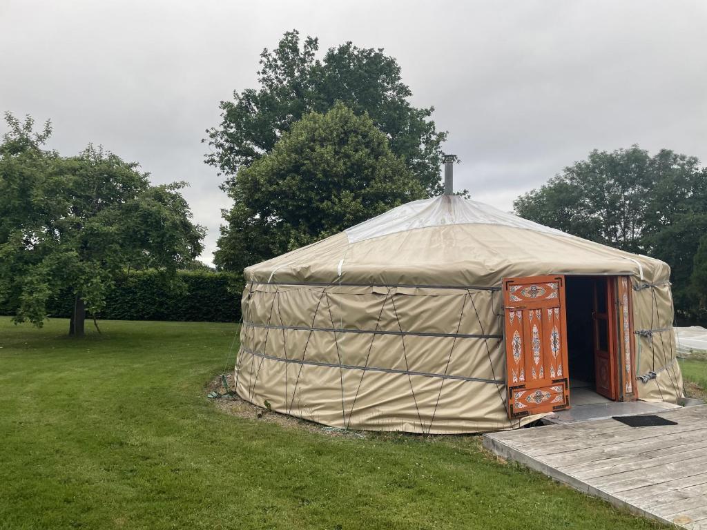a yurt with a wooden door in a field at Yourte Volcans Puy de Dome in Montfermy