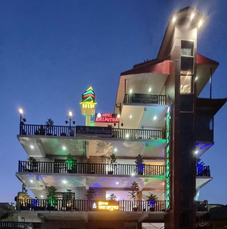 a building with a clock tower on top at night at Hotel Biaspushp Dalhousie in Banikhet
