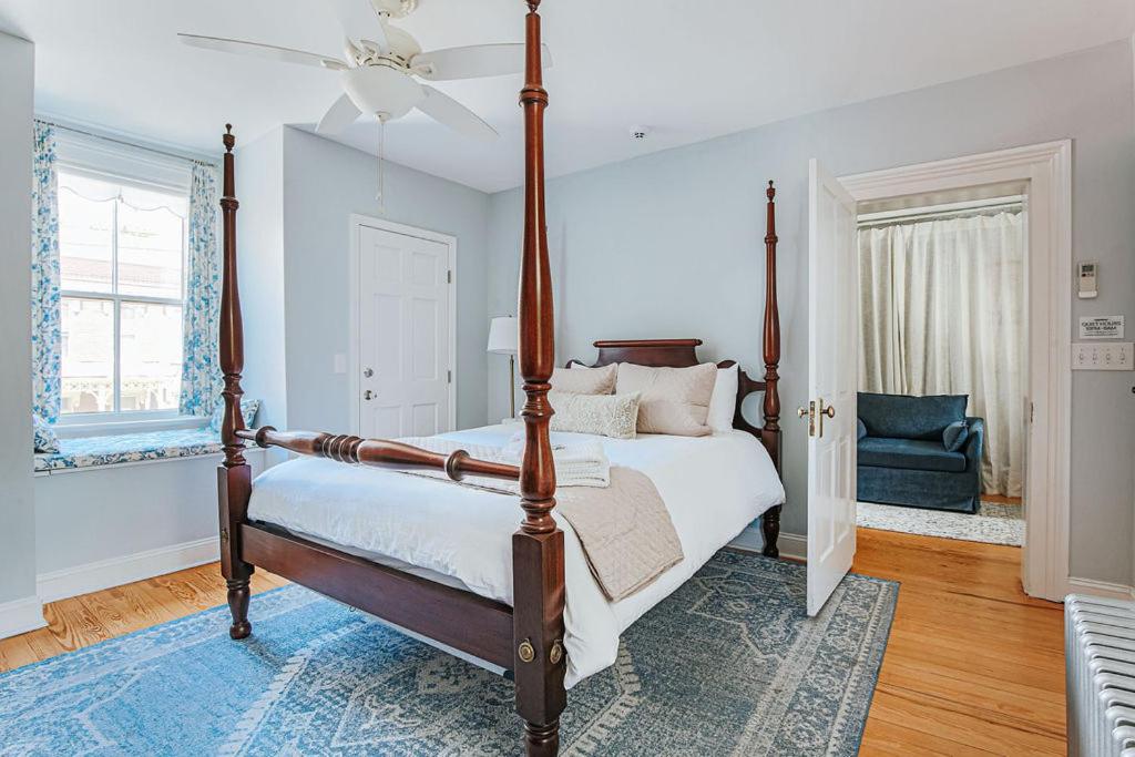 a bedroom with a canopy bed and a blue chair at Magnolia Suite in Staunton
