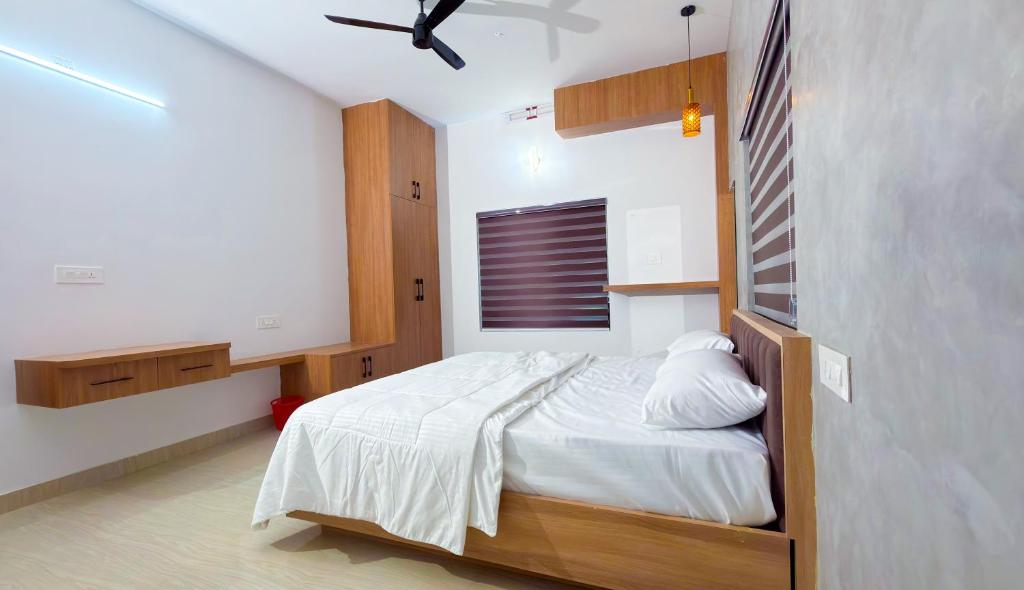 a bedroom with a bed and a ceiling fan at Thushara Homestay in Kozhikode