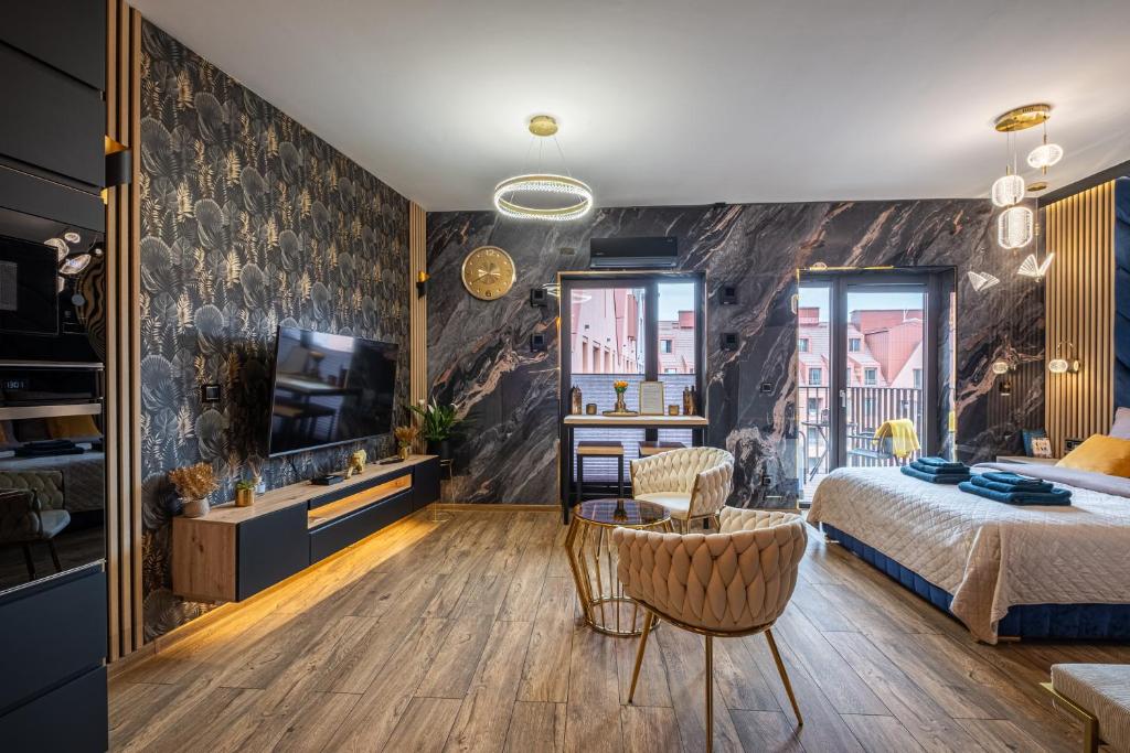 a bedroom with a bed and a tv and a couch at Golden Eagle Luxury Apartment - Granary Island- Gdańsk Old Town in Gdańsk