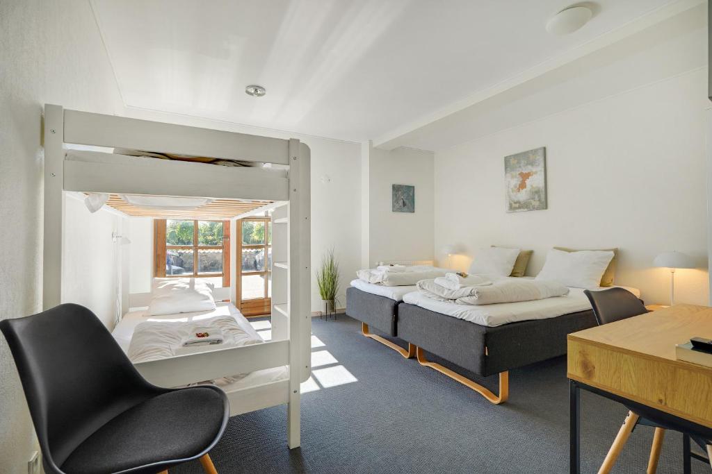 a bedroom with a bed and a desk with a chair at Skjoldbjerg Garnihotel in Vorbasse