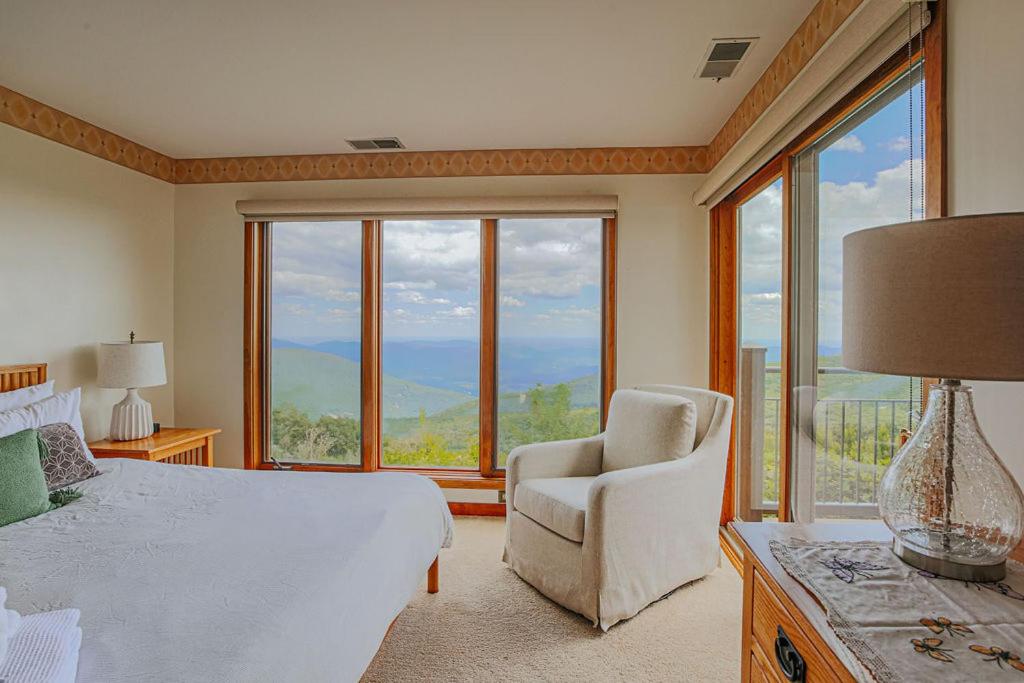a bedroom with a bed and a chair and a window at Panoramic Peak in Mount Torry Furnace