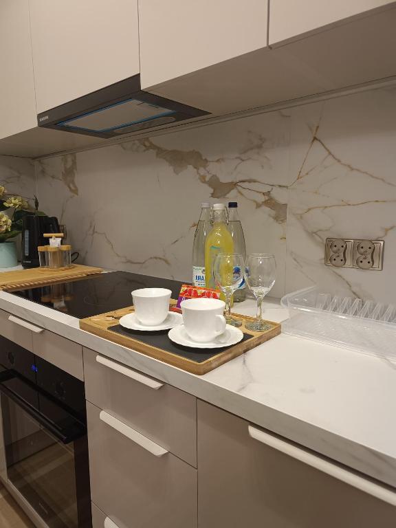 a kitchen counter with two cups and wine glasses at Blue Perła Premium in Kutno