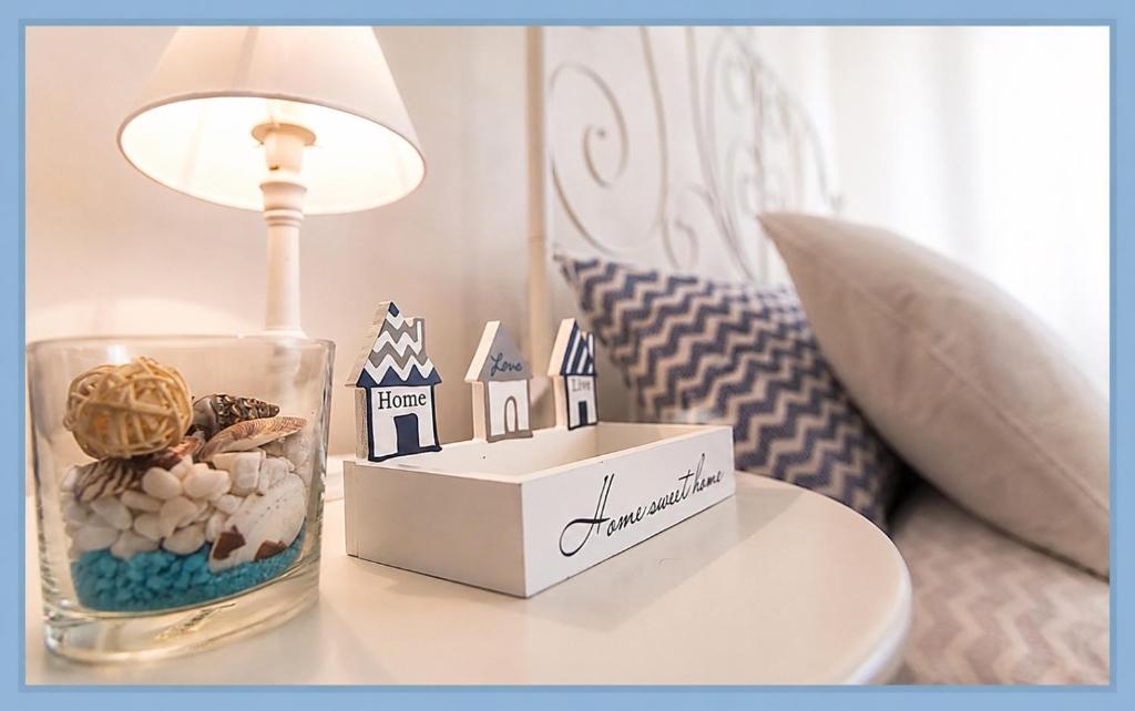 a table topped with a lamp and a table with a candle at White Charme Rooms -Self Check in- in Alghero