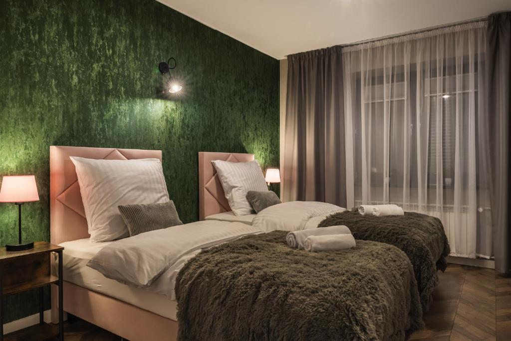 two beds in a bedroom with green walls at Cetyna Retreat - Dom w Beskidzie Sądeckim, 8 osób, szlaki, cisza, EV in Rytro
