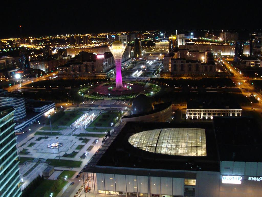 a view of a city at night with a fountain at Vip House Hotel in Astana