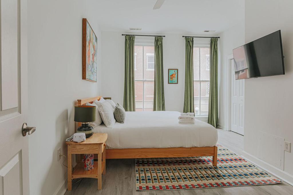 a bedroom with a bed and a table with a television at The Social Loft in Staunton