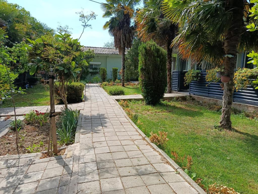 a walkway in front of a house with palm trees at Vila Katerina Dojran in Star Dojran