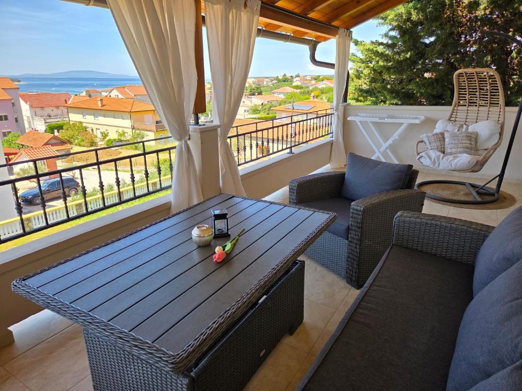 a patio with a table and chairs on a balcony at Apartments Manuel in Rab